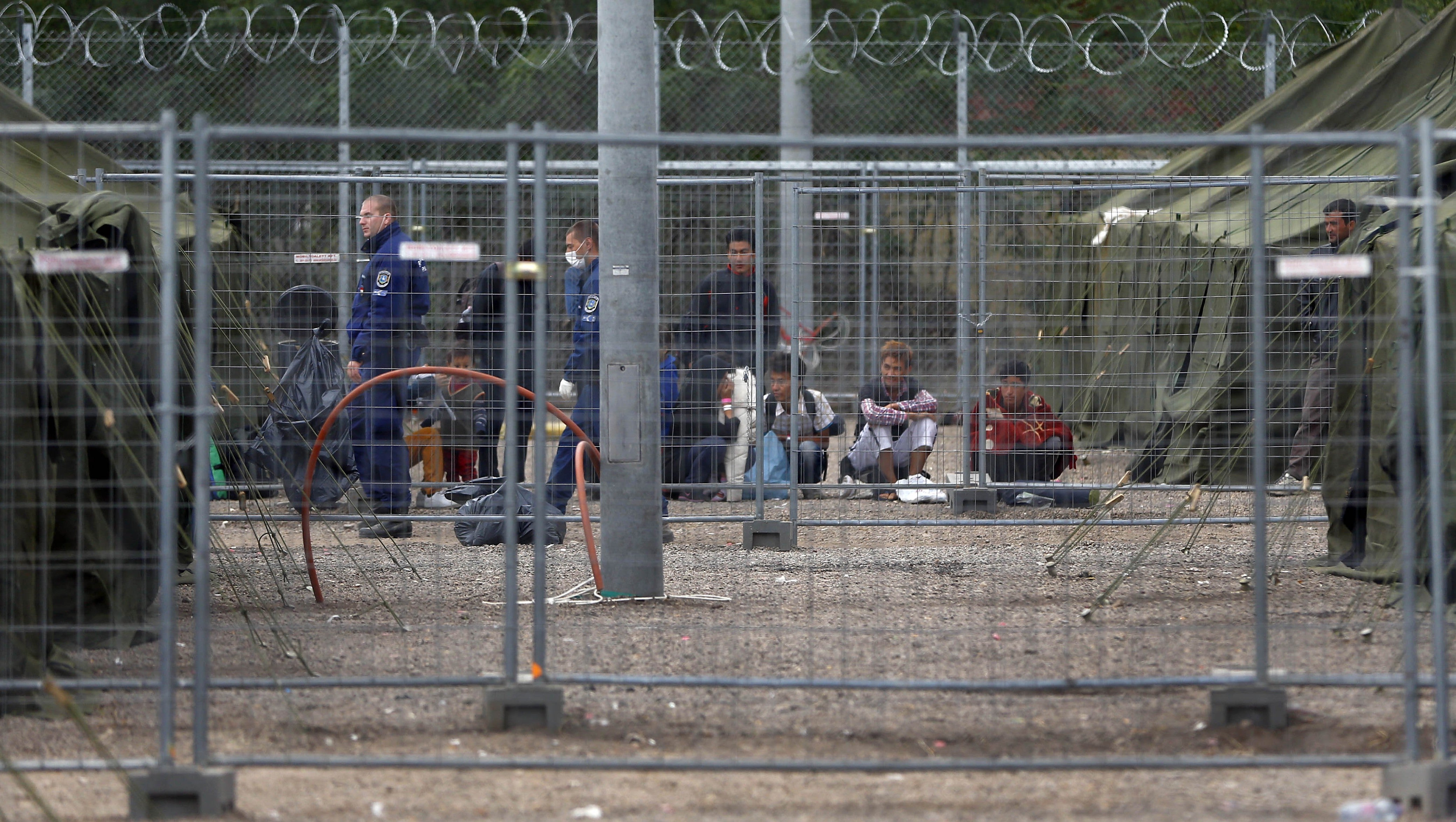 Video: Hungarian police treat refugees “like animals,” caging them and  throwing food